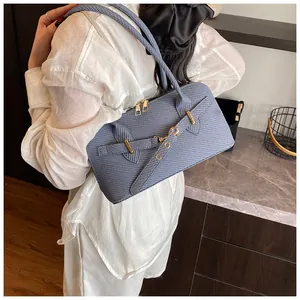 Détail du sac à main en cuir bleu texturé avec boucles dorées et double fermeture