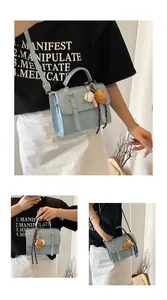 Detail of light blue crossbody bag with gold hardware and sports charm pendant