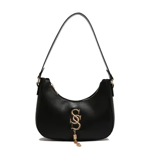 Sac hobo rétro noir en forme de croissant avec logo doré et détail de pompon