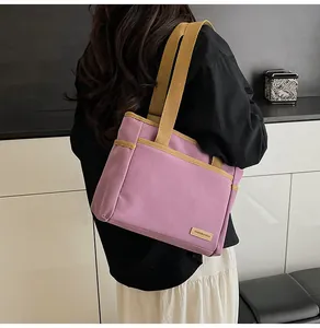 Close-up of a lilac canvas tote bag with reinforced beige straps and decorative label