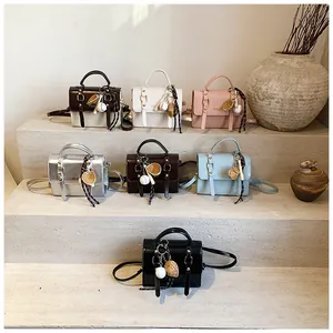 Collection of colorful mini crossbody bags with sports charms on stone steps