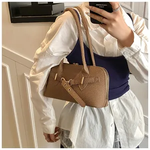 Détails d'un sac à bandoulière marron tressé avec boucle rétro et sangle réglable