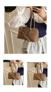 Gros plan du sac à main marron à texture tressée avec boucle de ceinture et double bandoulière