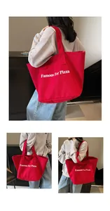 Detail einer roten Canvas-Tasche mit Famous For Pizza Aufdruck von einem Model gehalten