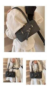 Détails du sac noir texturé avec boucle dorée et finitions métalliques élégantes