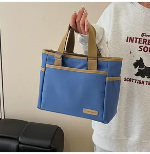 Detail of blue canvas tote bag with khaki straps and side pockets for daily use