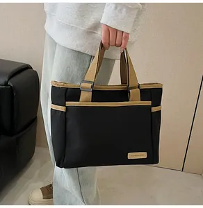 Close-up of black canvas tote bag with khaki trim and 'FASHION & BAGS' label detail