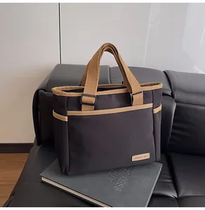 Close-up of contrast canvas tote bag with side pockets on a leather sofa
