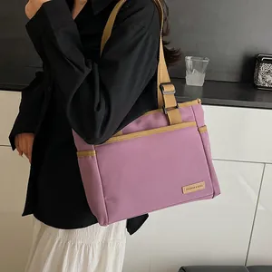 Sac fourre-tout minimaliste en toile violette avec bretelles kaki porté par un mannequin