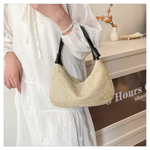 Detailaufnahme der beigen gewebten Handtasche mit schwarzen Ledergriffen und Reißverschluss