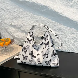 Grande borsa tote in tela bianca con stampe di farfalle nere e chiusura a cerniera
