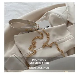 Dettaglio della borsa beige con tracolla in pelle e catena in metallo dorato