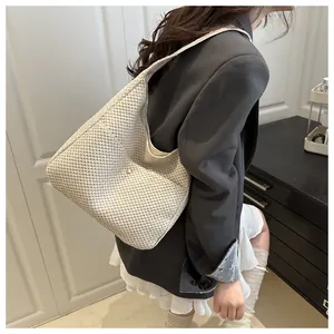 Détail du sac hobo en paille tressée blanc cassé avec bandoulière large et boucle en métal