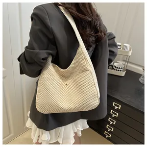 Détail du sac hobo en tricot crème montrant la texture tissée douce et le grand volume