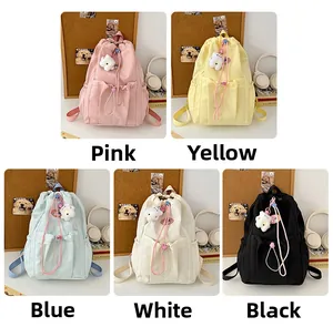 Detailed view of drawstring backpacks in five colors with cute plush pendants
