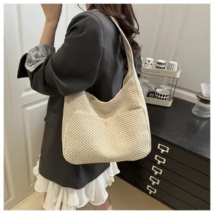 Détail du sac fourre-tout tissé crème avec motif texturé et poche magnétique pratique