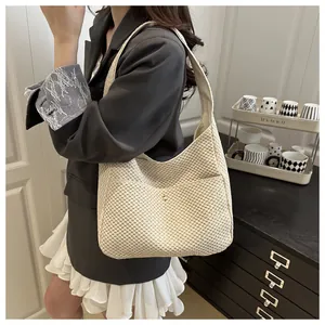 Détail du sac cabas tissé beige avec texture en maille et boucle magnétique en métal