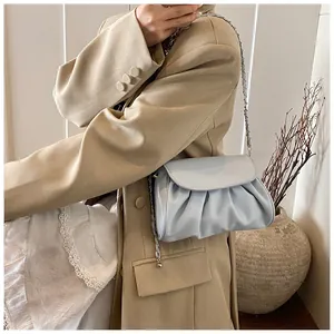 Detail view of light blue ruched cloud bag with silver metal and leather chain strap
