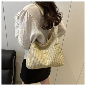 Détail du tissage et du bouton pression en métal sur ce grand sac cabas en paille