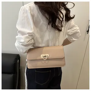 Dettaglio borsa a tracolla in pelle PU beige con fibbia dorata sulla modella