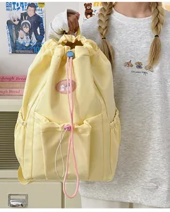 Detalle de mochila amarilla con cordón rosa y parche de cachorro para uso cotidiano