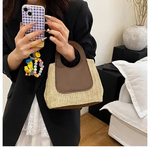 Detail of raffia straw handbag with contrast brown leather handle for summer fashion