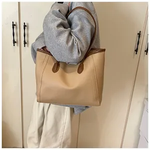 Close-up of large tote bag in beige lychee leather with brown contrast straps
