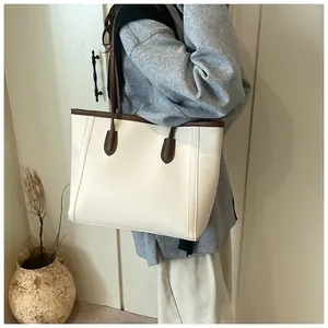 Detailed side view of off-white tote bag with brown straps on model for daily commuting