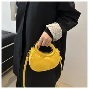 Dettaglio della borsa gialla a pieghe che mostra la texture e i dettagli dorati