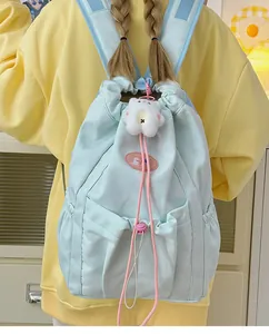 Detalle de la mochila azul menta con cordón, cordones rosas y colgante de osito de peluche