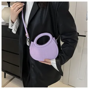 Dettaglio della borsa a pieghe viola chiaro con manico integrato e tracolla regolabile