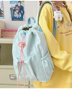 Detalle de la mochila azul claro con cordones rosas y bolsillos laterales elásticos