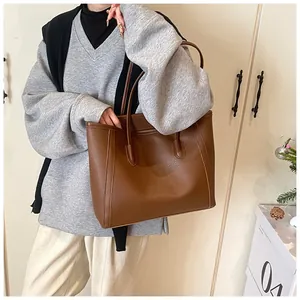 Brown lychee leather tote bag shown on model's shoulder for daily work commute