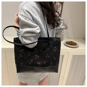 Close-up of black cherry print tote bag featuring leather bottom and slim shoulder straps