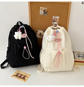 Detalle de mochila con cordón que muestra el colgante de oso y la hebilla rosa