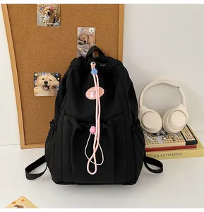 Detalle de mochila negra con cordón y cintas rosas y bordado de gato adorable