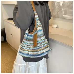 Detail of bohemian knit tote bag with colorful zigzag patterns and brown leather strap