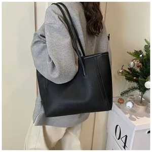 Macro shot of black pebbled leather tote bag with slim shoulder straps for daily use