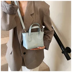 Dettaglio della mini borsa tote azzurra con doppi manici e scritta dorata decorativa