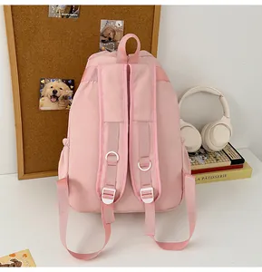 Vista trasera de la mochila rosa con correas acolchadas y hebillas blancas