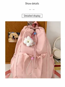 Pink waterproof nylon backpack with drawstring pockets and white flower plush charm