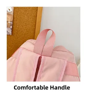 Detail showing the comfortable handle and fine stitching of the pink nylon backpack