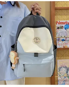 Nahaufnahme des dreifarbigen Nylon-Rucksacks mit süßem Toast-Anhänger und stilvollen Farben
