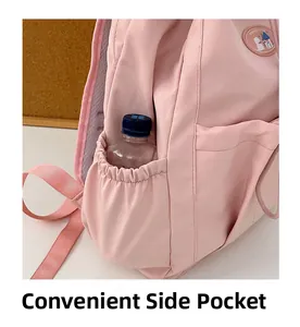 Close-up of a pink backpack side pocket with an elastic band holding a water bottle