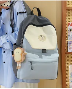 Detailansicht des modischen Colorblock-Rucksacks mit süßem Toast-Anhänger und Logo-Patch
