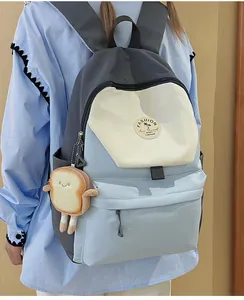 Detail eines Nylon-Rucksacks im Color-Block-Design mit Mode-Badge und Plüsch-Anhänger