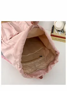 Internal display of pink drawstring backpack featuring a zipper pocket and spacious lining