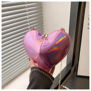 Detailed macro of pink heart-shaped crossbody bag with iridescent finish and gold zippers