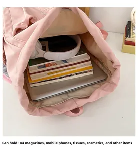 Macro view of pink drawstring backpack interior with laptop and A4 magazines capacity