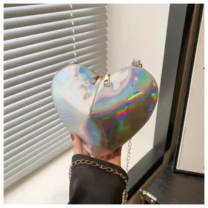 Close-up of holographic heart-shaped crossbody bag with golden chain and dual zippers